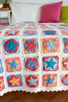 a crocheted bed spread with multicolored stars on it