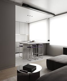 a living room filled with furniture next to a kitchen