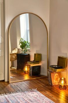 an arch in the corner of a room with various items on it and candles lit up