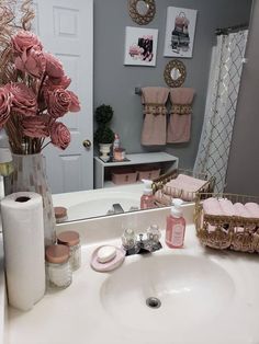 a bathroom sink with pink flowers and toiletries on top of it next to a mirror