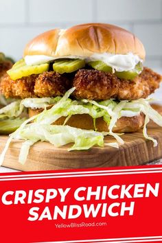 crispy chicken sandwich on a cutting board with lettuce and pickles