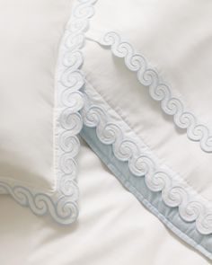 the comforter is made up with white sheets and blue trimmings on it