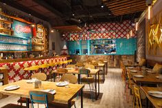 the interior of a restaurant with wooden tables and colorful wallpapers on the walls