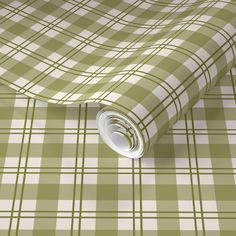 a green and white checkered wallpaper with a rolled up roll on it's side