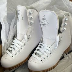 a pair of white roller skates sitting on top of a box