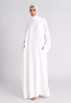 Our premium textured plain white abaya is made from highest quality of polyester and crepe fabric. Extreme care is taken during the manufacturing process to ensure the fit and the stitching quality is at the optimum standard giving you the premium feel where compromise is not an option. The White Textured Abaya features Zip pockets in the seam of the abayas which remains hidden and is perfect for daily and casual wear. Ideal for Hajj, Umrah, Ramadan and daily wear. Also available in various othe Abaya For Hajj, Hajj Outfit For Women, Abaya For Umrah, Umrah Outfit, Dubai Kaftan Dress, Abayas Collection, Closed Abaya, White Abaya, White Hijab