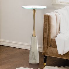 a white table with a glass top in a living room next to a couch and chair