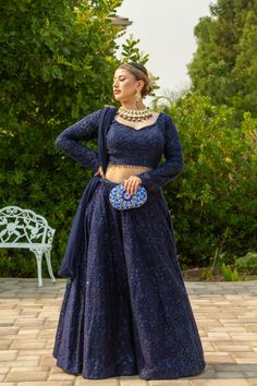 Adorned with intricate self-sequins, this deep blue masterpiece is sure to dazzle in the Adhara Lehenga. The look is completed with a full-sleeve blouse and a net dupatta that has been embellished with sparkling details. Pure luxury awaits in the Adhara Lehenga, an incredible work of art in a deep blue hue with intricate self-sequins that will leave you mesmerized. Team it up with an intricately designed full-sleeve blouse paired with a net dupatta embellished with sparkly details for the fashio Blue Lehenga Full Sleeve, Full Sleeves Blouse Design For Lehenga, Lehenga Designs Full Sleeves, Long Sleeve Choli With Sheer Dupatta For Navratri, Midnight Blue Lehenga, Designer Long Sleeve Lehenga With Sheer Dupatta, Reception Long Sleeve Blouse With Sheer Dupatta, Long Sleeve Traditional Wear With Sequins For Navratri, Festive Evening Lehenga With Long Sleeves