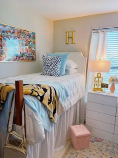 a bedroom with a bed, dresser and pictures on the wall