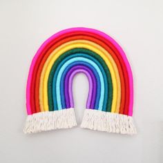 a rainbow wall hanging with fringes on it