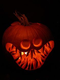 a pumpkin carved to look like a tiger's face with teeth and fangs on it