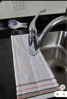 a kitchen sink with a white towel on it and a faucet next to it