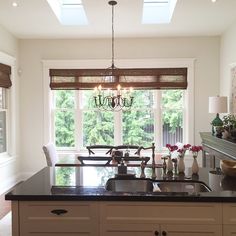 a kitchen with a sink, stove and window in it's center island next to a dining room table