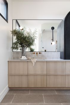 a bathroom with a large mirror and wooden cabinets