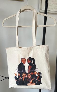 This canvas tote bag is perfect for the Barack and Michelle fan!  Spacious yet compact, the perfect addition to your wardrobe and the perfect gift for any occasion! FREE Surprise gift with purchase of any two items! *Natural, off-white color *100% cotton canvas fabric *Measures 15x15 *Machine wash inside-out in cold water with like colors; line dry Unique Tote Bag. Barack Obama. Michelle Obama. Obama Memorabilia. Presidental Gifts. Election Gift. Messenger Bag. Photo Gift Bag. Cheap Birthday Gif Obama Michelle, Cheap Birthday Gifts, Unique Tote Bag, Barack And Michelle, Photo Bag, Cotton Canvas Fabric, Gift With Purchase, Photo Gift, Birthday Gif