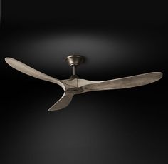 a ceiling fan that is on top of a black wall in a room with dark lighting