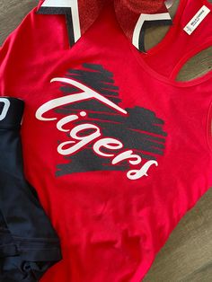 With cheer tryouts right around the corner, or Friday Spirit Day, this tank with matching bow combo is perfect for game day. Tank and bow only. Tank is a white or black Bella and canvas Razorback tank top. TO PURCHASE : Leave message in comments high school initials and mascot name along with school colors. Please specify size (youth or ladies) and color of tank top. Team discount for orders of 10 or more. Just message me so I can make a separate listing personally for you. Team Spirit Red Sleeveless Tops, Team Spirit Sleeveless Tank Top For Sports, Collegiate Sleeveless Tops For Cheerleading, Sporty Stretch Tops For Cheerleading, Stretch Sporty Tops For Cheerleading, Game Day Cotton Racerback Tank Top, Game Day Sleeveless Tank Top With Letter Print, Game Day Letter Print Sleeveless Tank Top, Sports Fan Sleeveless Tops For Game Day