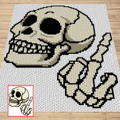 a cross stitch rug with a skull and bones on the floor in front of it