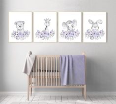 three paintings on the wall of a baby's room with a crib and blanket