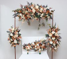 an arrangement of flowers and greenery on a white backdrop for a wedding or ceremony