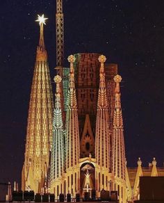 the building is lit up at night with lights on it's sides and spires