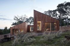 the house is made out of wood and has two windows on each side, along with sliding glass doors to let in natural light