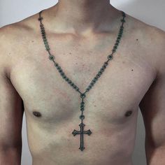 a shirtless man wearing a rosary necklace with a cross on it's chest