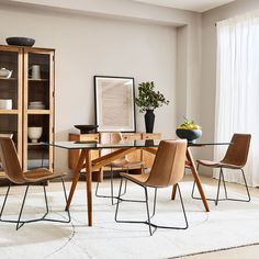 a dining room table with chairs and a book shelf in the corner next to it