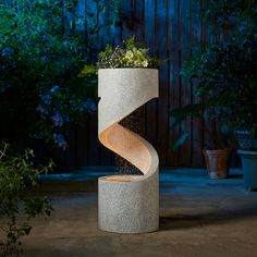 a planter that is sitting in the middle of a concrete structure with a spiral design on it