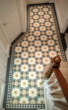 an ornate tiled hallway with stairs leading up to the door and another room on the other side