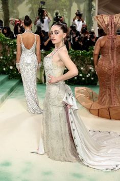 a woman in a white dress standing on a runway