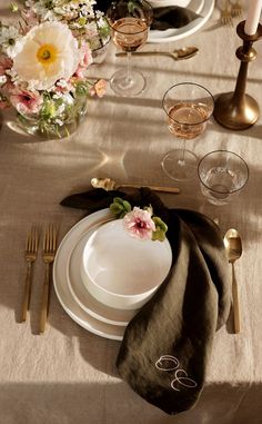 the table is set with white plates and silverware