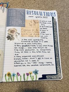 an open notebook with writing on it and flowers in the pages that have been altered