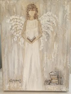 an angel painting with books and a book on the ground next to it, in front of a white background