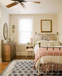 a bed room with a neatly made bed and a ceiling fan