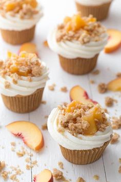 cupcakes with white frosting and fresh peaches on the top are ready to be eaten