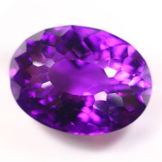 an oval shaped purple diamond on a white surface