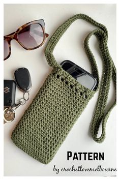 a crocheted cell phone case sitting on top of a table next to sunglasses