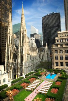 an aerial view of a large cathedral with lawns and flowers in the foreground