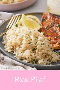 rice and salmon on a plate with lemon wedges next to a glass of water