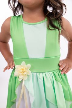 When you twirl in this enchanted green dress, it's as if you're caught in a joyful breeze, and the skirt flutters like the leaves in a magical forest. Designed for twirling - cut from a full circle of fabric which allows it to billow out as your little one spins and dances Gracefully tiered skirt, with three layers of flowing fabric that cascade elegantly Sunshine-hued flower embellishment at the waist for a finishing touch Made from breathable, stretchy, mid-grade soft knit fabrics Accessories Sleeveless Green Princess Dress For Spring, Sleeveless Green Princess Dress For Summer, Summer Sleeveless Green Princess Dress, Green Sleeveless Dress For Dress-up Occasions, Green Princess Dress For Summer Dress-up, Fitted Fairytale Princess Dress For Spring, Green Fairy Dress For Dress-up, Green Princess Dress For Dress-up, Fairy Style Sleeveless Dress For Garden Party