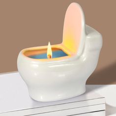 a white toilet with a lit candle in it