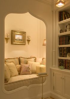 a living room filled with furniture and bookshelves next to a wall mounted book shelf