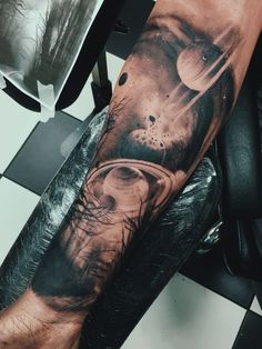 a man's arm with an image of the planets on it and his face