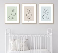 three framed art prints on the wall above a crib