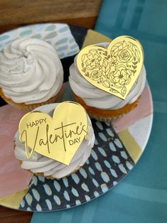 two cupcakes on a plate decorated with hearts and the words happy valentine's day