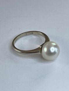 . This pearl is lovely. It's luster is so high you can see your reflection. It's a nice white color with just the slightest hint of pink. The 14k white gold mounting is clean simple lines that really show off the pearl. The band is 2mm at the pearl and 1.5mm wide at the back. I've cleaned with only dawn dish soap and a toothbrush. 10mm cultured Pearl 3.62 grams 14k and pearl Size 6 3/4 Modern White Pearl Ring For Anniversary, Classic White Pearl Ring For Gifts, Formal White Gold Ring With Pearl Drop, Formal Silver Pearl Drop Ring, White Oval Brilliant Cut Pearl Ring, White Pearl Drop Ring For Formal Occasions, Classic Round Pearl Ring With High Luster, Classic Oval Akoya Pearl Ring, Formal Hallmarked White Gold Pearl Ring