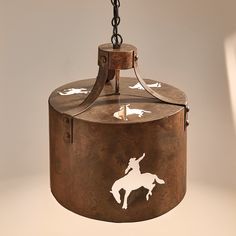 a light fixture with a horse and rider painted on the side, hanging from a chain