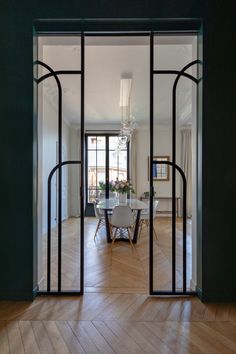 an open door leading to a dining room with a table and chairs in the center