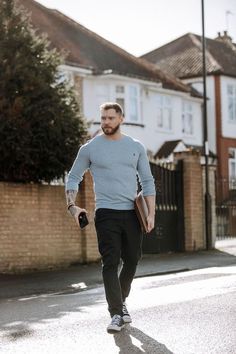 a man walking down the street with his hand in his pocket